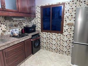 a kitchen with a refrigerator and a washer at Appartement in Khouribga