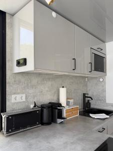 a kitchen with white cabinets and a sink at Design-Hausboot am Rheinsteig in Lorch am Rhein