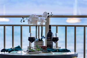 a table with wine glasses and flowers on a balcony at OB - Lahaina Roads 308 in Lahaina