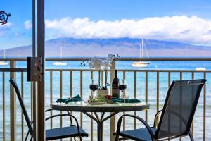 a table on a balcony with a view of the ocean at OB - Lahaina Roads 308 in Lahaina