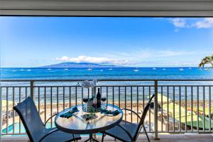 a table on a balcony with a view of the beach at OB - Lahaina Roads 308 in Lahaina +35 photos