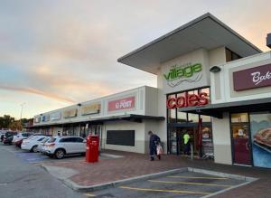 a store with cars parked in a parking lot at Layover Lounge in Perth