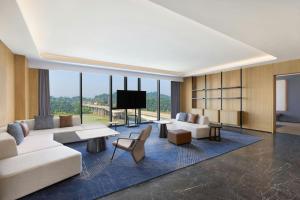 a living room with a couch and a tv at Four Points by Sheraton Leshan in Leshan