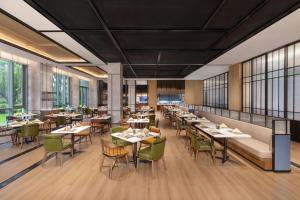 a restaurant with tables and chairs and windows at Four Points by Sheraton Leshan in Leshan