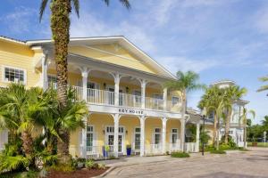 a yellow building with palm trees in front of it at Marriott's Harbour Lake in Orlando