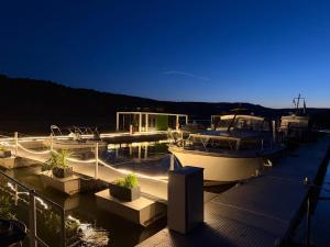 a boat is docked at a dock at night at Design-Hausboot am Rheinsteig in Lorch am Rhein +4 photos