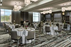 a banquet room with white tables and chairs and windows at AC Hotel Asheville Downtown in Asheville