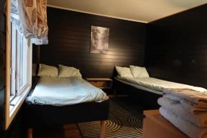 two beds sitting in a room with a window at Ditt andra hem in Kiruna