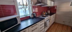 a kitchen with a black counter top and red tiles at Ditt andra hem in Kiruna