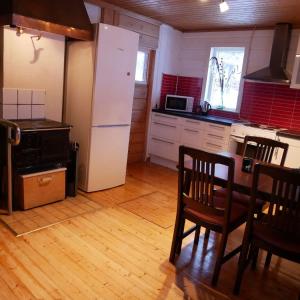 a kitchen with a white refrigerator and a table and chairs at Ditt andra hem in Kiruna