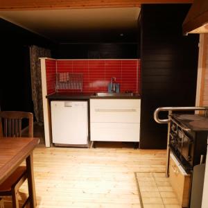 a kitchen with red tile on the wall at Ditt andra hem in Kiruna +6 photos