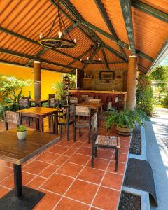 a restaurant with tables and chairs and a roof at Villa Edallys in Capira