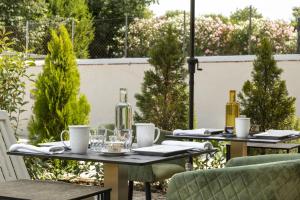 two tables with bottles on them on a patio at Villa La Tuia B&B in Lucca