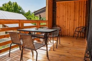a patio with chairs and a table on a deck at Cottage Deera in Mestia +4 photos