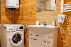 a bathroom with a washing machine and a sink at Cottage Deera in Mestia