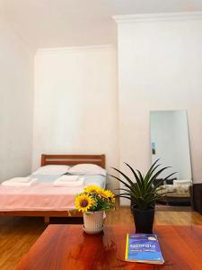 a bedroom with a bed and a table with flowers at Legacy Rooms in Old Tbilisi FREE parking in Tbilisi City +15 photos