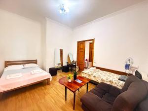 a living room with a bed and a couch at Legacy Rooms in Old Tbilisi FREE parking in Tbilisi City