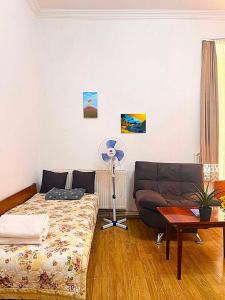 a living room with a couch and a fan at Legacy Rooms in Old Tbilisi FREE parking in Tbilisi City
