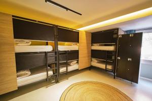a room with two bunk beds with a rug at U-nit Hostel Central Park in Valencia +59 photos