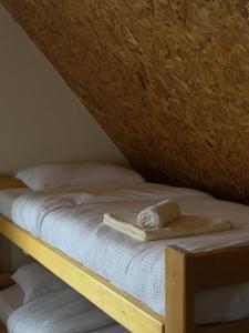 a wooden bed with a towel on top of it at Villa Harmonia in Ferizaj