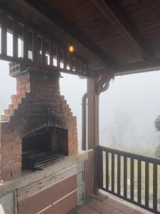 a brick fireplace on a porch with a view at Villa Harmonia in Ferizaj
