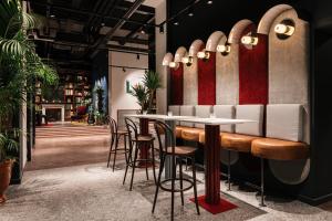 a restaurant with a bar with stools at Ruby Frida Hotel Stockholm by IHG in Stockholm