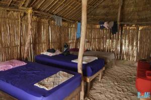 a room with three beds in a straw hut at Arriyaladub traditional cabins San blas in Masargantupo