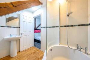 a bathroom with a sink and a bath tub at RB1GH- Cosy Room SECURE PARKING NEAR CITY CENTRE FAST WIFI in Bramley