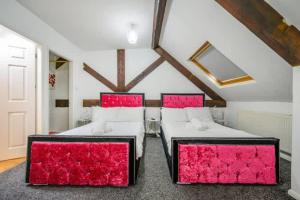 two beds in a room with red pillows at RB1GH- Cosy Room SECURE PARKING NEAR CITY CENTRE FAST WIFI in Bramley