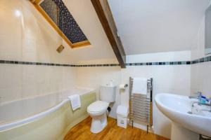 a bathroom with a white toilet and a sink at RB1GH- Cosy Room SECURE PARKING NEAR CITY CENTRE FAST WIFI in Bramley