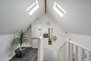 a white staircase with a potted plant and skylights at RB1GH- Cosy Room SECURE PARKING NEAR CITY CENTRE FAST WIFI in Bramley +5 photos