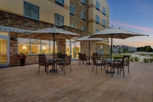 a patio with tables and chairs with umbrellas at Fairfield by Marriott Inn & Suites Mattoon in Mattoon