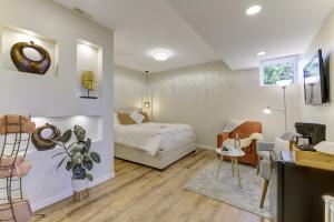a bedroom with a bed and a living room at Unwind centrally in West Kelowna