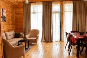 a living room with a couch and chairs and a table at Cottage Deera in Mestia