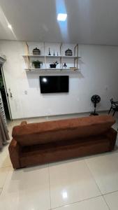 a living room with a couch and a flat screen tv at Apartamento 2 Quartos centro da cidade in Parauapebas