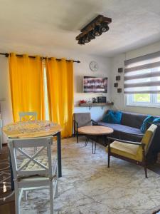 a living room with yellow curtains and a couch at ALBAK Green Zone in Gradačac