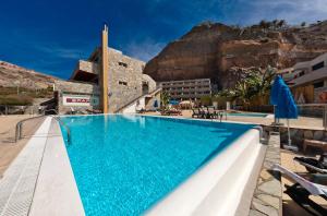 a pool at a hotel with a mountain in the background at Terraza de Amadores in Puerto Rico de Gran Canaria