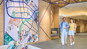 two men standing in a lobby with a mural at Holiday Inn Express Sapporo Susukino by IHG in Sapporo