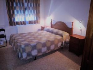 Habitación pequeña con cama y mesita de noche en Alojamiento CR Cuatro Caminos, en San Pablo de los Montes