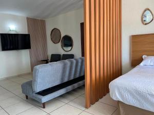 a bedroom with a bed and a couch and a television at Hermoso condominio frente al mar in San Carlos +5 photos