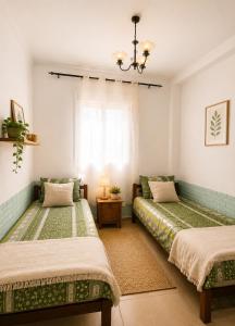 a bedroom with two beds and a window at chic appart vue sur piscine in Tangier