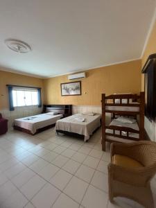 a large room with two beds and a chair at Pousada Pesque Park in Boracéia +66 photos
