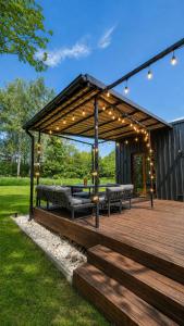 a wooden deck with benches and lights on it at RoyalRelax Apartament w Lesie z Jacuzzi, Kinem domowym 88' - Białystok in Choroszcz