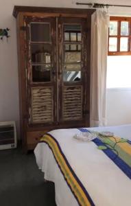 a bedroom with a wooden cabinet and a bed at Pousada Vidinha Bela in Brazópolis +55 photos