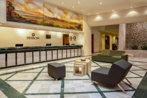 a lobby of a hotel with furniture and a painting at Fiesta Inn Ciudad Juarez in Ciudad Juárez