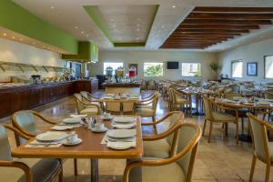 a dining room with wooden tables and chairs at Fiesta Inn Ciudad Juarez in Ciudad Juárez