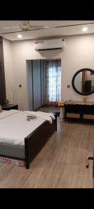 a bedroom with a large bed and a mirror at White420 apartment in Rawalpindi