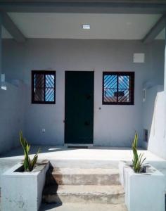 a room with a green door and two potted plants at JF Condominio 