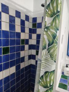 a bathroom with a shower with blue and white tiles at La Muralla in Yunquera