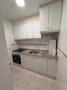a kitchen with white cabinets and a sink at Villa Bella in Los Altos